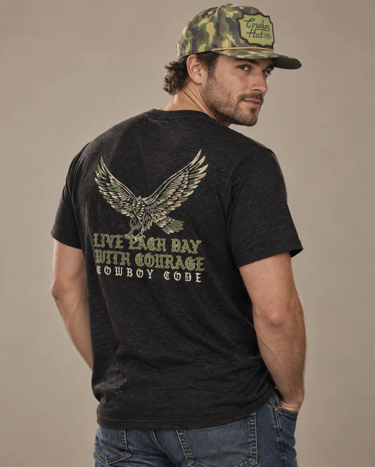 Male model in Cowboy Code No. 1 Live Each Day With Courage tee, Charcoal-Black and Woodland Camo rope hat, Cowboy Revolution