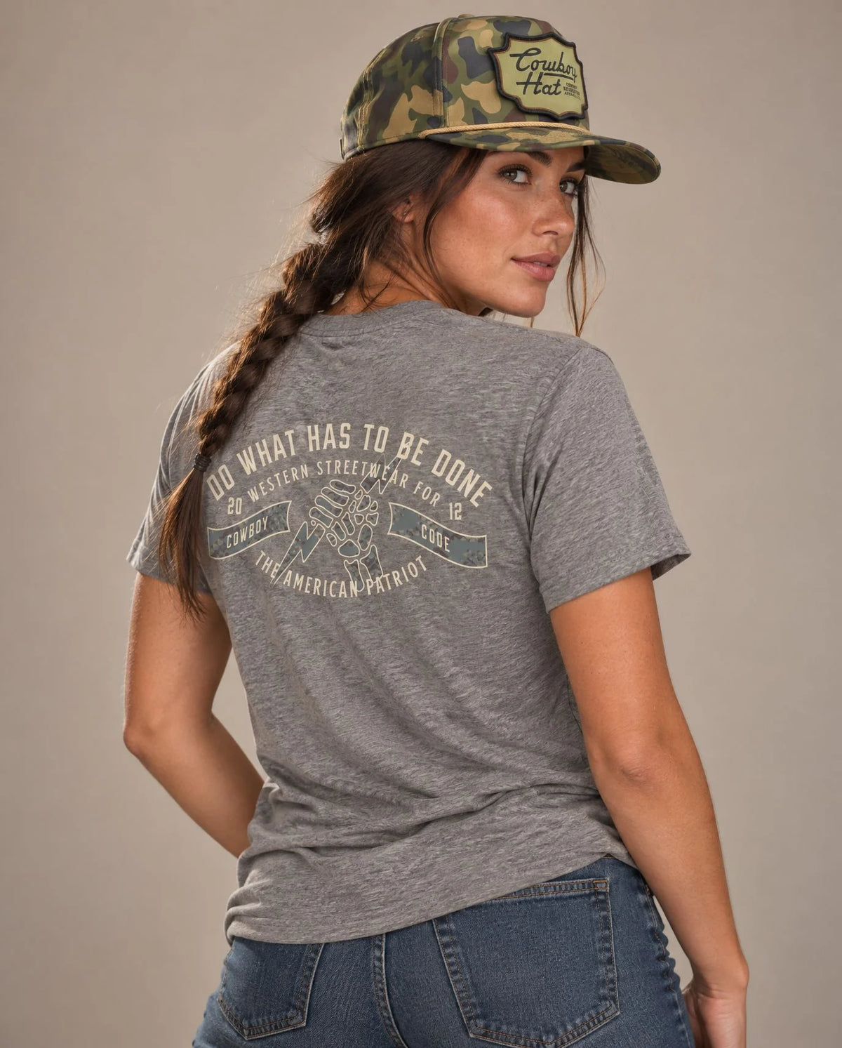 Female model in Cowboy Code No. 4 Do What Has to Be Done tee, Grey and Woodland Camo rope hat, Cowboy Revolution